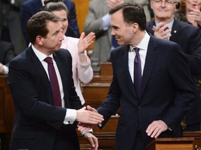 Finance Minister Bill Morneau, right, is congratulated by Treasury Board President Scott Brison after delivering the federal budget in the House of Commons in Ottawa on Tuesday, Feb. 27, 2018.