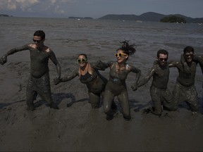 Mud covered revellers play in the mud during the traditional "Bloco da Lama" or "Mud Block" carnival party in Paraty, Brazil, Saturday, Feb. 10, 2018. (AP Photo/Leo Correa)