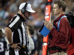 Referee Bill Vinovich, left, reviews a video replay on a handheld screen on the sideline during the first half of an NFL game between the Patriots and Chiefs, Sept. 7, 2017, in Foxborough, Mass.