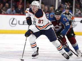 Edmonton Oilers centre Connor McDavid drives down ice with the puck as Colorado Avalanche winger Gabriel Landeskog pursues during NHL action on Feb. 18, 2018, in Denver.