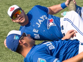 Toronto Blue Jays outfielder Steve Pearce, top, chats with catcher Luke Maile while warming up at spring training in Dunedin on Feb. 21, 2018