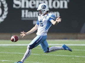Argos' Swayze Waters hammers a punt in the third quarter of the Labour Day Classic against the Tiger-Cats at Tim Horton's Field  on September 1, 2014. Jack Boland/Toronto Sun