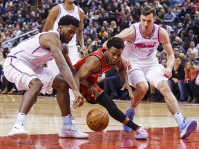 Toronto Raptors Kyle Lowry, centre, battles for the ball with Miami Heat Goran Dragic, right, and Justise Winslow during the first half of NBA basketball action in Toronto, Tuesday February 13, 2018. (THE CANADIAN PRESS/Mark Blinch)