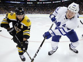 Toronto Maple Leafs' Morgan Rielly (44) and Boston Bruins' Brad Marchand (63) battle for the puck during the second period of an NHL hockey game in Boston, Saturday, Nov. 11, 2017.
