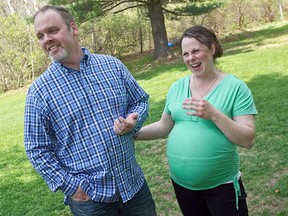 In this May 6, 2015 file photo, Kateri and Jay Schwandt stand outside their Rockford, Mich. home. The couple, who have 13 boys, are expecting their 14th child, due in April of 2018. (Chris Clark/The Grand Rapids Press via AP, File)