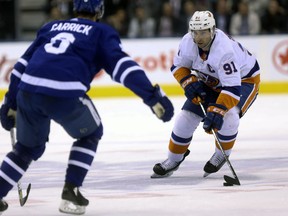 New York Islanders centre John Tavares is checked closely by Toronto Maple Leafs defenceman Connor Carrick during a game in Toronto on Jan. 31, 2018