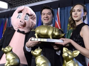Canadian Taxpayers Federation federal director Aaron Wudrick, centre, stands with mascot Porky the Waster Hater, left, and event hostess Jessica Eccles after presenting the Teddy Awards for Government Waste, during a press conference on Parliament Hill in Ottawa on Wednesday, Feb. 14, 2018.