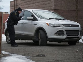 A Peel Police Constable Dan Carrier checks out an abandoned vehicle in Scarborough that they suspects was involved in a fatal hit & run in Mississauga that killed a 61 year old. Saturday February 17, 2018.