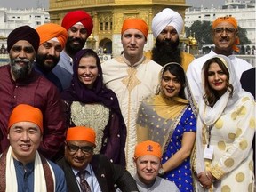 Prime Minister Justin Trudeau, centre, stands beside Surrey Centre MP Randeep Sarai, top middle right, as they join fellow MPs for a group photo while visiting the Golden Temple in Amritsar, India on Wednesday, Feb. 21, 2018.