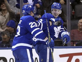 Toronto Maple Leafs defenceman Travis Dermott (23) congratulates teammate Justin Holl after he scored against the New York Islanders in Toronto on Thursday February 1, 2018. (Jack Boland/Toronto Sun)