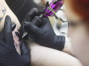 A tattoo artist at work. (THE CANADIAN PRESS/AP/Peninsula Clarion, Kelly Sullivan)
