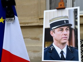 A portrait of French Lieutenant-Colonel Arnaud Beltrame is pictured during  a minute of silence, on March 28, 2018 at the Interior Ministry in Paris.