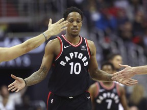 Raptors guard DeMar DeRozan is greeted by teammates earlier this season. (THE CANADIAN PRESS)