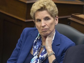 Premier Kathleen Wynne listens to her throne speech being delivered in Ontario's legislature on Monday. (STAN BEHAL, Toronto Sun)