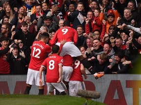 Manchester United players celebrate after Marcus Rashford scores the opening goal against Liverpool on Saturday.
 (GETTY IMAGES)