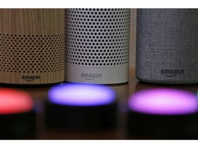 FILE - In this Sept. 27, 2017, file photo, Amazon Echo and Echo Plus devices, behind, sit near illuminated Echo Button devices during an event announcing several new Amazon products by the company in Seattle.  Amazon is expanding its home-security business by buying Ring, the maker of Wi-Fi-connected doorbells. The deal comes months after the online retailer started selling its own Wi-Fi-connected indoor security cameras, which work with its voice-assistant Alexa.