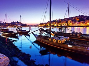 Traditional "rabelo" boats, which were once used to deliver port wine from the Douro Valley, line Porto's harbour at sunset.