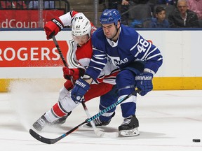 Jeff Skinner of the Carolina Hurricanes battles against Roman Polak of the Toronto Maple Leafs during an NHL game at the Air Canada Centre on Dec. 19, 2017