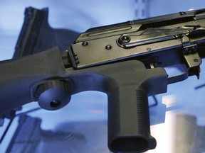 In this Oct. 4, 2017, photo, a device called a "bump stock" is attached to a semi-automatic rifle at the Gun Vault store and shooting range in South Jordan, Utah.