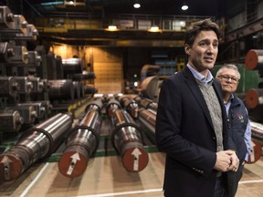 Prime Minister Justin Trudeau, center right, speaks to media while Public Safety Minister Ralph Goodale looks on at EVRAZ Regina, a steel company in Regina, Sask., on Wednesday, March 14, 2018.