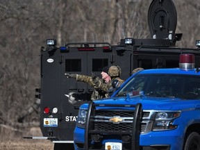 Law enforcement officers search a wooded area for a suspect involved in a shooting at a Central Michigan University residence hall on Friday, March 2, 2018 in Mt. Pleasant, Mich.