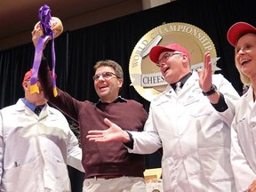 Sylvain Diedrichs, a representative of Savencia Cheese USA of New Holland, Penn., holds the Best in Show winner during the finals of the World Championship Cheese Contest at Monona Terrace in Madison, Wis., Thursday, March 8, 2018. (John Hart/Wisconsin State Journal via AP)