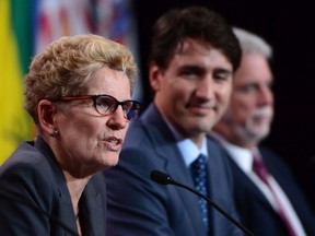 Prime Minister Justin Trudeau (centre) and Quebec Premier Philippe Couillard (right) look on as Ontario Premier Kathleen Wynne addresses the closing news conference at the First Ministers meeting in Ottawa on Tuesday, Oct. 3, 2017. THE CANADIAN PRESS/Sean Kilpatrick