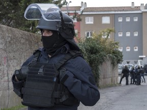 Police cordon off the area of a raid at the residence of a man suspected of killing three people and injuring a dozen others in Carcassonne, southern France, on Friday, March 23, 2018