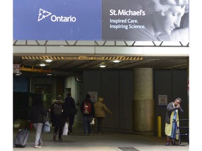 People make their way pass construction at St. Michael's Hospital Queen street entrance in Toronto on Thursday Nov. 23, 2017. A new study is urging hospitals to reduce the number of paper documents they produce in order to protect patient privacy.