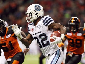 Toronto Argonauts' James Wilder Jr. avoids the tackle from B.C. Lions' players at BC Place in Vancouver on November 4, 2017. (THE CANADIAN PRESS/Chad Hipolito)