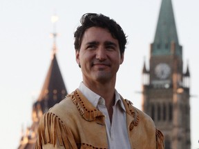 Prime Minister Justin Trudeau takes part in the National Aboriginal Day Sunrise Ceremony on the banks of the Ottawa River in Gatineau, Quebec on Tuesday, June 21, 2016. The Canadian Parliament building in Ottawa are seen in the background.