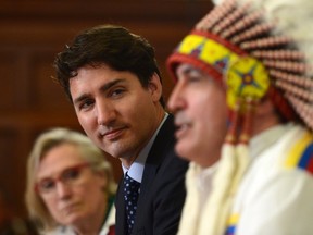 Minister of Indigenous and Northern Affairs (now Crown-Indigenous Relations) Carolyn Bennett, left, looks on as Prime Minister Justin Trudeau and Assembly of First Nations Chief Perry Bellegarde participate in the signing of the Assembly of First Nations-Canada Memorandum of Understanding on Joint Priorities on Parliament Hill in Ottawa on June 12, 2017. (Sean Kilpatrick/THE CANADIAN PRESS)