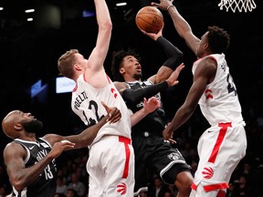 Toronto Raptors centre Jakob Poeltl and forward Pascal Siakam defend Brooklyn Nets forward Rondae Hollis-Jefferson during an NBA game on March 13, 2018