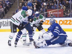 Toronto Maple Leafs goaltender Frederik Andersen (31) clears the puck in front of Dallas Stars left wing Jamie Benn (14) and Maple Leafs defenceman Ron Hainsey (2) during first period NHL hockey action in Toronto on Wednesday, March 14, 2018. THE CANADIAN PRESS/Chris Young