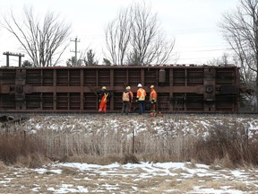 A CN crew works on an overturned freight train car just east of Kingston, Ont. on Saturday, March 3, 2018. All train traffic on the line has been halted.