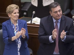 Ontario Premier Kathleen Wynne and Finance Minister Charles Sousa applaud during the throne speech at the Ontario legislature in Toronto on Monday, March 19, 2018. THE CANADIAN PRESS/Chris Young