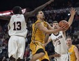 Ryerson Rams' Manny Diressa, centre, drives to the basket between Carleton Ravens Munis Tutu, left, and Cam Smythe during the second half of semifinal action in the U Sports men's basketball national championship in Halifax on Saturday, March 10, 2018. THE CANADIAN PRESS/Darren Calabrese