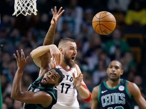 Boston Celtics' Kadeem Allen, left, and Toronto Raptors' Jonas Valanciunas (17) battle for a rebound during the second quarter of an NBA basketball game in Boston, Saturday, March 31, 2018.