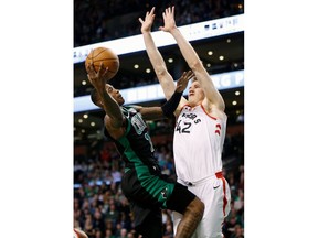 Boston Celtics' Terry Rozier (12) shoots against Toronto Raptors' Jakob Poeltl (42) during the first quarter of an NBA basketball game in Boston, Saturday, March 31, 2018.