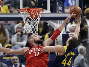 Indiana Pacers' Bojan Bogdanovic has his shot blocked by Toronto Raptors' Jonas Valanciunas Thursday, March 15, 2018, in Indianapolis. (AP Photo/Darron Cummings)