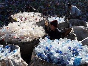 Labourers collect assorted plastic products from a garbage pile at a recycling center on the outskirts of Beijing, China, on December 17, 2008.