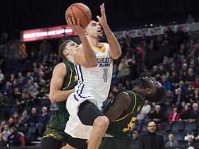 Ryerson Rams' Manny Diressa, centre, drives between Alberta Golden Bears Brody Clarke, left, and Ivan Ikomey during the second half of quarterfinal action in the USports men's basketball national championship in Halifax on Thursday, March 8, 2017. THE CANADIAN PRESS/Darren Calabrese ORG XMIT: DBC119