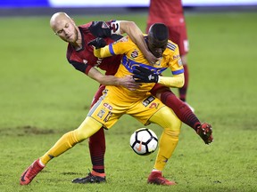 Toronto FC midfielder Michael Bradley (4) grabs at the jersey of UANL Tigres forward Enner Valencia (13) as they vie for control of the ball during first half CONCACAF Champions League quarter-final action, in Toronto on Wednesday, March 7, 2018. THE CANADIAN PRESS/Frank Gunn