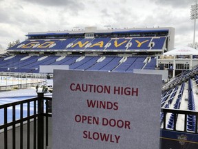 A sign warns of high winds as workers finish work on Navy–Marine Corps Memorial Stadium, Friday, March 2, 2018, in Annapolis, Md., for the outdoor NHL hockey game between the Toronto Maple Leafs and Washington Capitals.
