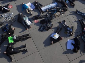 Supporters of Safe Streets, a Toronto-based advocacy organization made up of people who have experienced, or have been bereaved by, road violence, stage a 'die-in' outside city hall in Toronto on Monday, March 26, 2018. THE CANADIAN PRESS/Chris Young
