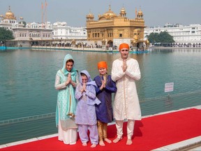 In this handout photo, Prime Minister Justin Trudeau (R), along with his wife Sophie Gregoire Trudeau (L), daughter Ella-Grace (2nd L) and son Xavier (2nd R) pose for a family photo as they pay their respects at the Sikh Golden Temple in Amritsar on Feb. 21, 2018.