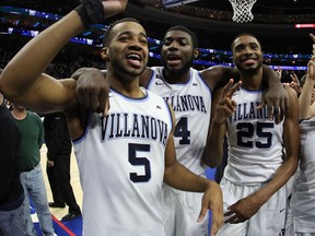 Villanova's Phil Booth, left, celebrates the win with Eric Paschall, center, and Mikal Bridges after the second half of an NCAA college basketball game against Georgetown on March 3, 2018
