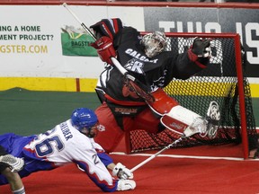 Roughnecks goalie Frank Scigliano, tries to make a save on the Rock’s Tom Schreiber. Schreiber suffered a partially-torn PCL on Feb. 10 (Leah Hennel/Postmedia)