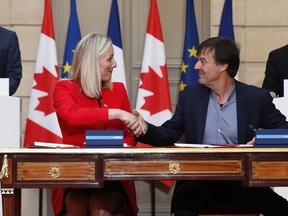 French President Emmanuel Macron (R) and Canadian Prime Minister Justin Trudeau (L) look on as French Minister for the Ecological and Inclusive Transition Nicolas Hulot (2nd R) and Canadian Minister of Environment and Climate Change Catherine McKenna (2nd L) shake hands as they sign an ecology agreement at the Elysee Palace in Paris on April 16, 2018. (IAN LANGSDON/AFP/Getty Images)