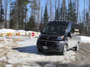 A Timmins Police Service forensic identification van is seen parked on Dalton Road, in front the barriers where Price Road has been closed. Six kilometres beyond this barrier, police say a charred 2004 Chrysler Intrepid was discovered with the human remains of four individuals. (RON GRECH/Postmedia)